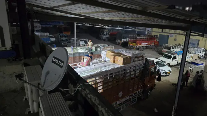 Busy goods transport depot yard with trucks being loaded for dispatch across Himachal Pradesh